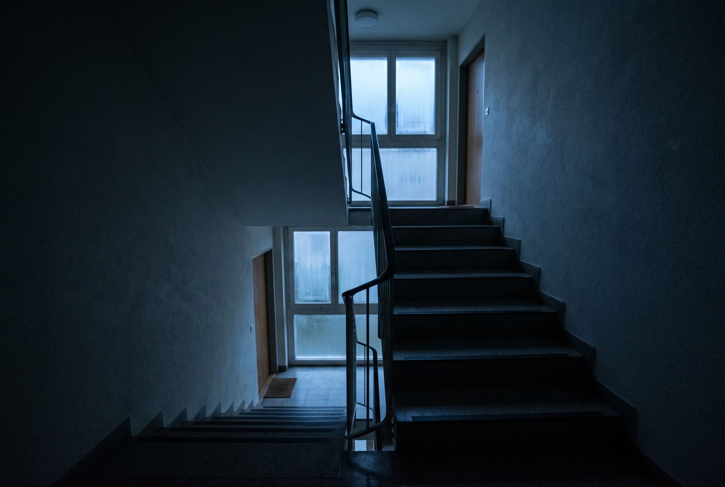 Cage d’escalier sombre d’un immeuble locatif le soir pendant une coupure de courant